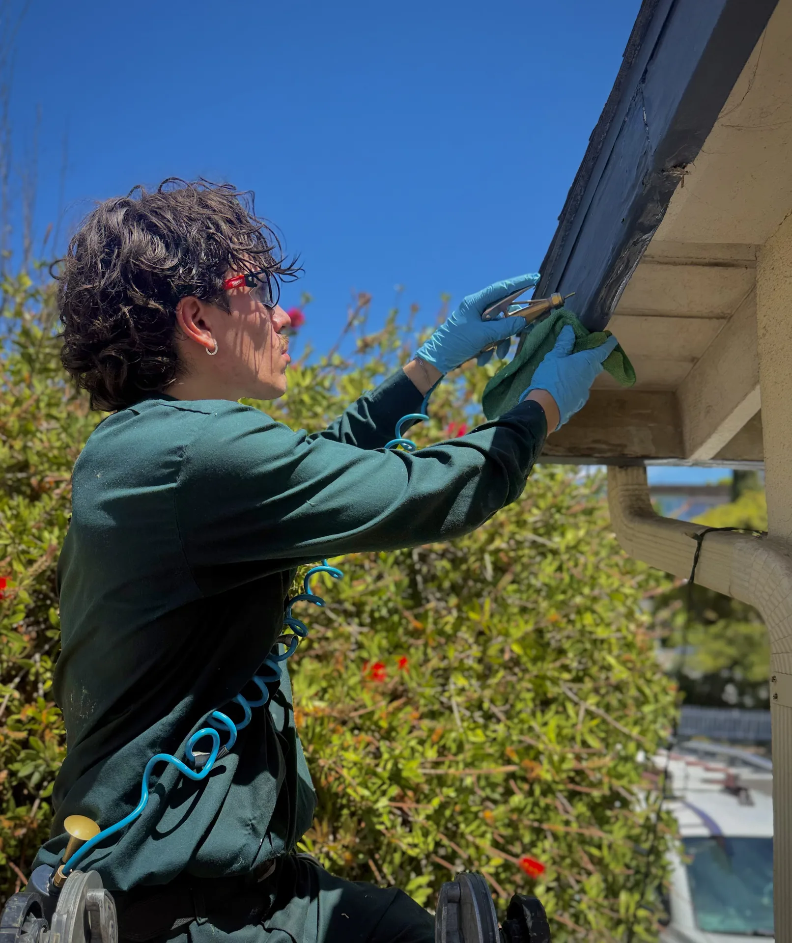 Anaheim termite technician inspecting eaves under roofline